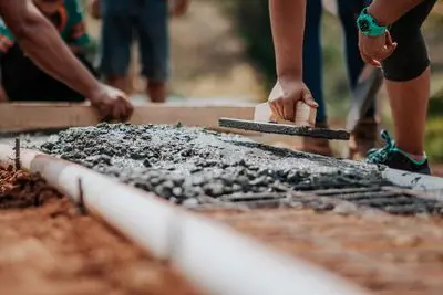 Workers pouring and finishing a concrete driveway