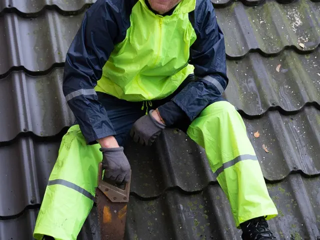 Roofer working on roof tiles with safety gear